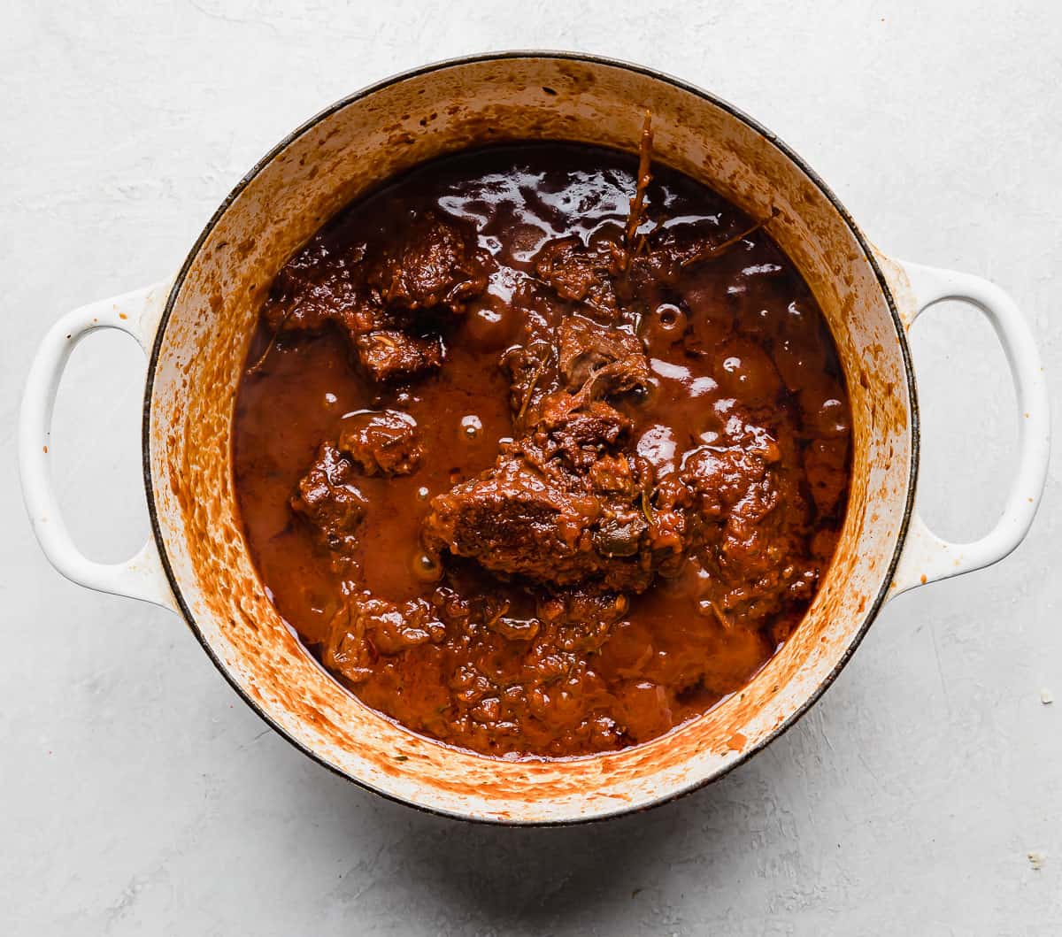 Beef Ragu in a white pot on a white background.