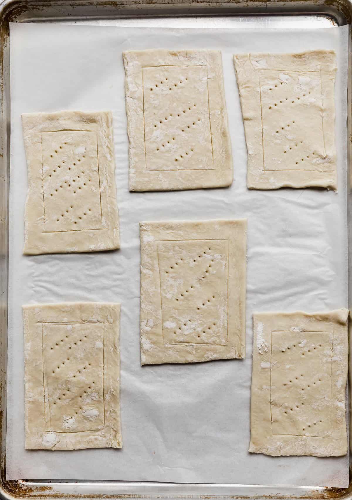 Six puff pastry rectangles with fork tine holes in the center of each.