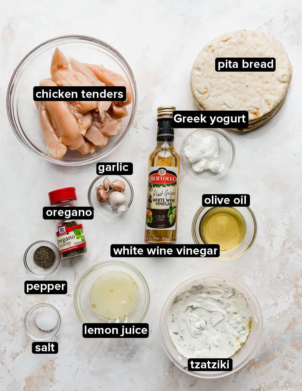 Greek Chicken Gyros ingredients on a white textured background.