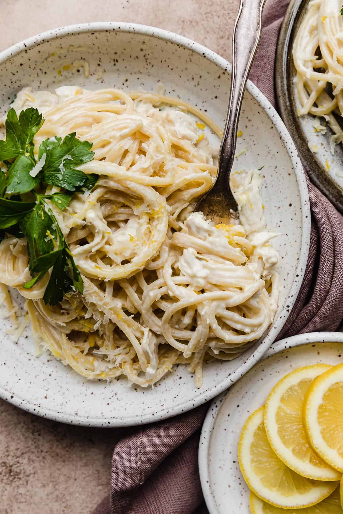 A white plate with Creamy Lemon Chicken Pasta made with spaghetti noodles.