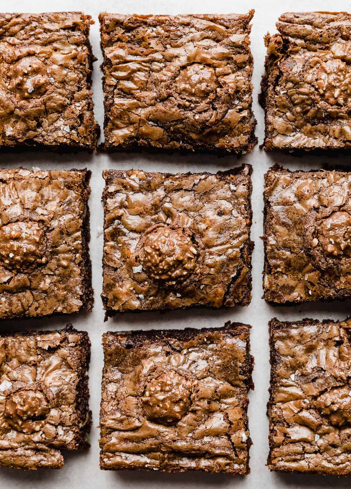 Overhead photo of Ferrero Rocher Brownies cut into squares with a Ferrero Rocher candy on top.