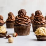Ferrero Rocher Cupcakes topped with a swirl of chocolate frosting and a Ferrero Rocher candy.