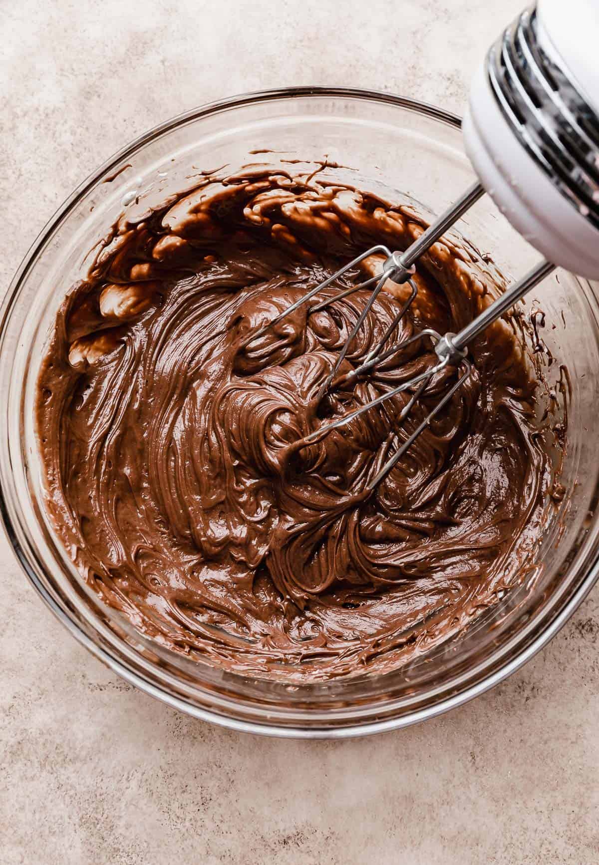 Hand beaters mixing Nutella and whipped cream to make a homemade whipped Nutella.