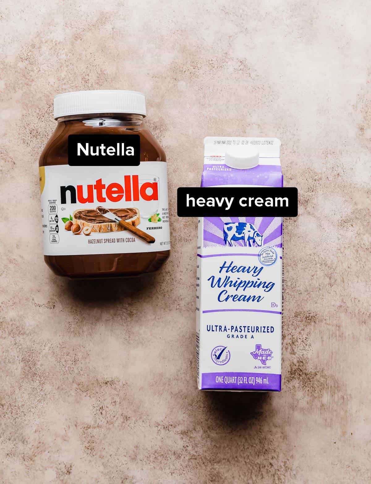 A jar of Nutella and heavy whipping cream on a light brown background.