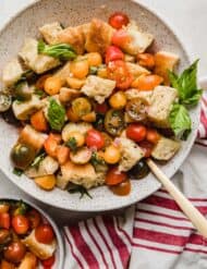 A bowl filled with panmolle or Panzanella Toscana with stale bread, chopped tomatoes, and fresh basil.