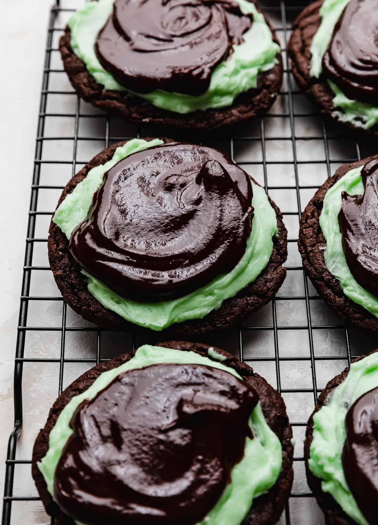 Ganache topped Mint Brownie Cookies on a wire cooling rack.