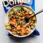 A plate of Catalina dressing taco salad on a bag of blue cool ranch Doritos.