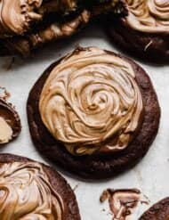 A brownie cookie topped with melted chocolate and peanut butter that has been swirled together.