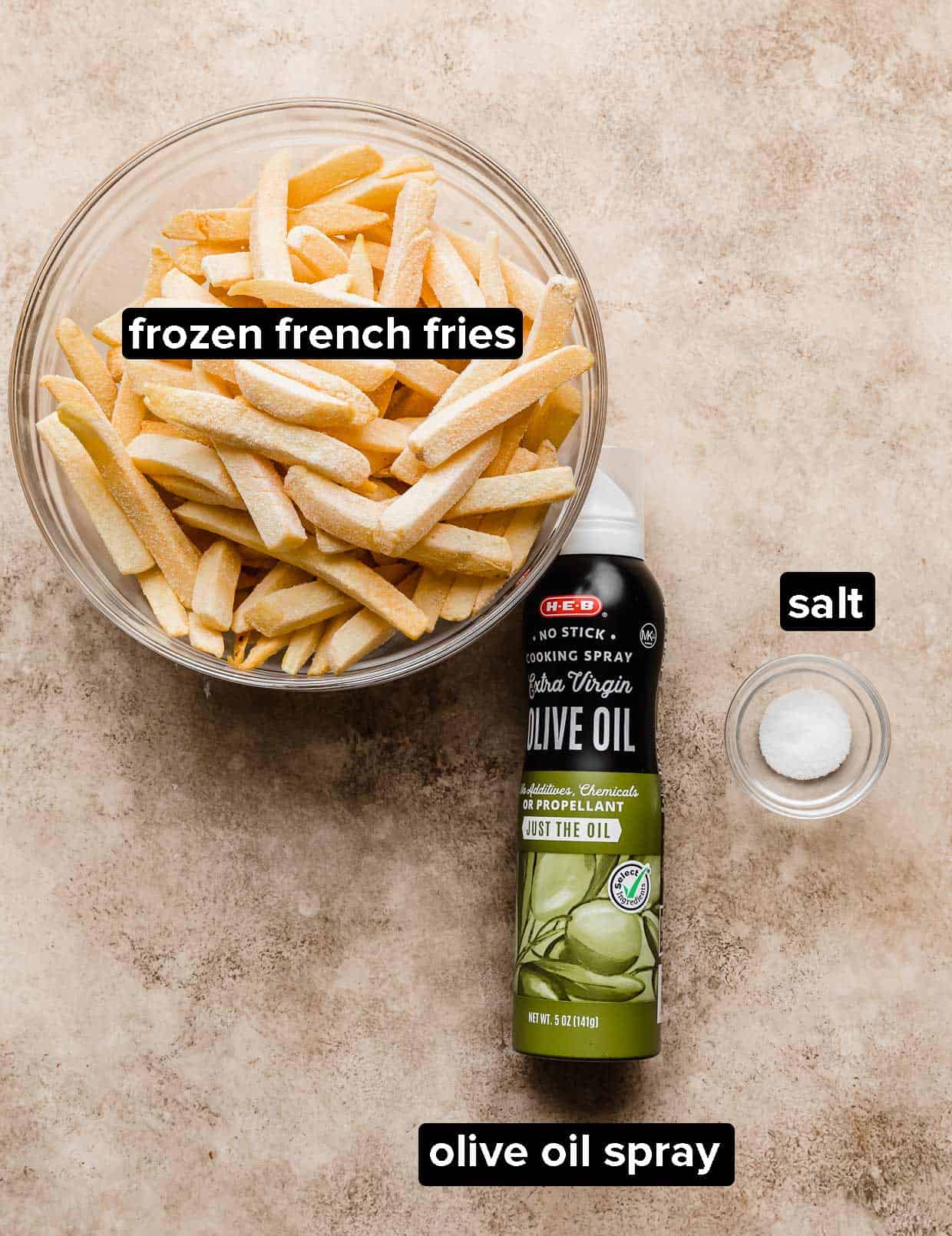 Ingredients used to make Air Fryer Frozen French Fries on a tan textured background.