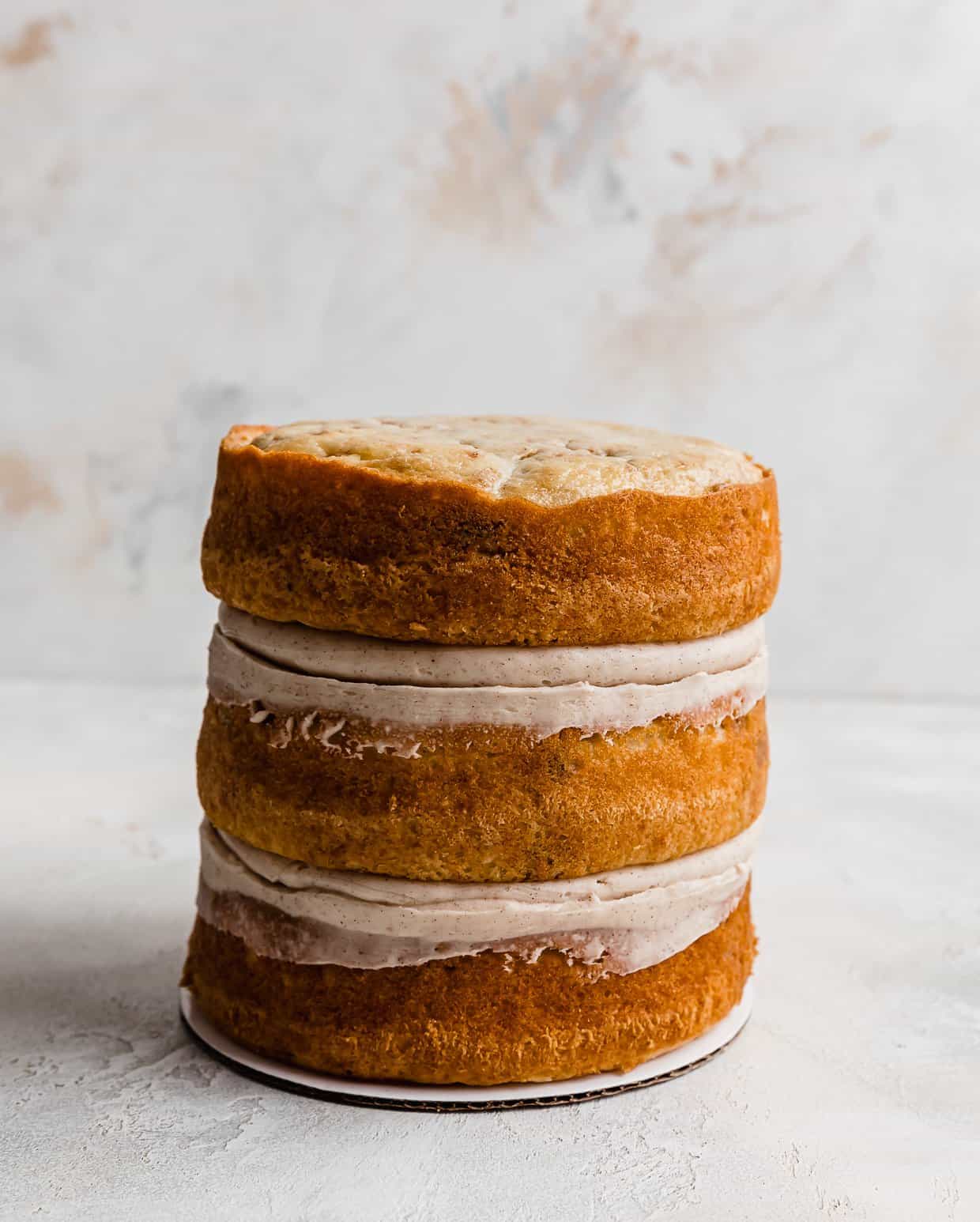 Three round Coconut Cinnamon Cake layers stacked on top of each other.