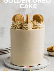 A Golden Oreo Cake on a white plate against a white textured background with the words "Golden Oreo Cake" written in white over the cake.