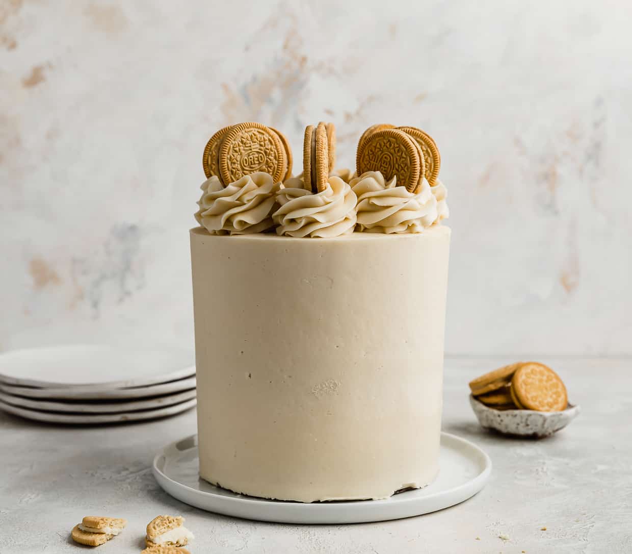 A Golden Oreo Cake against a white and cream textured background.