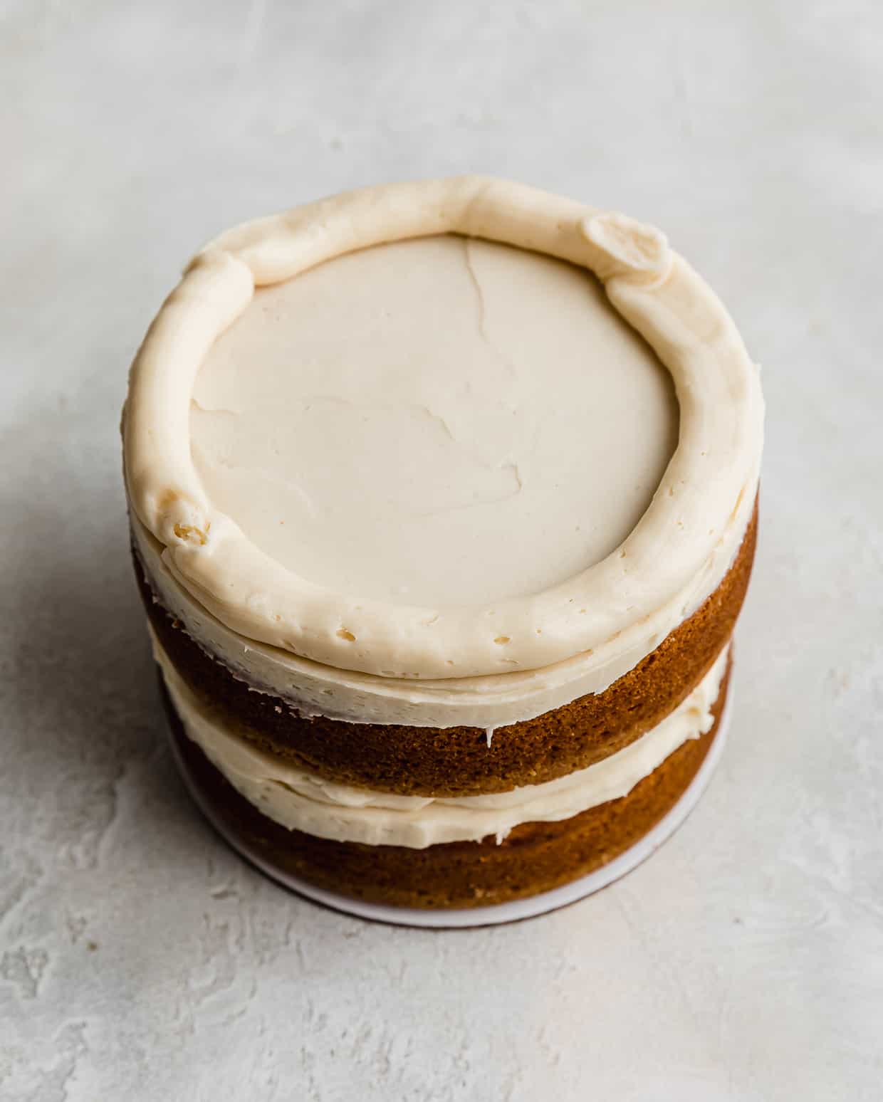 A Golden Oreo buttercream frosting piped along the perimeter of a cake layer.