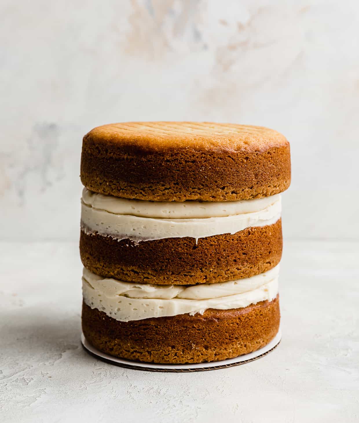 Three Golden Oreo cake layers stacked on top of each other against a white background.