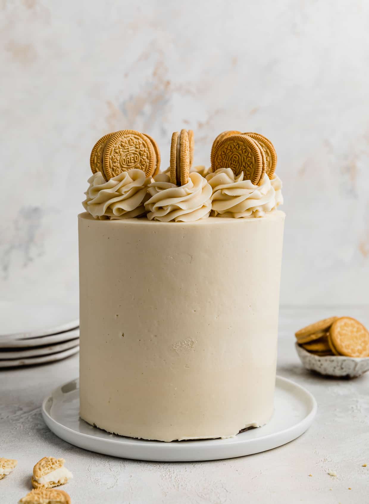 A Golden Oreo Cake topped with frosting swirls and Golden Oreos.
