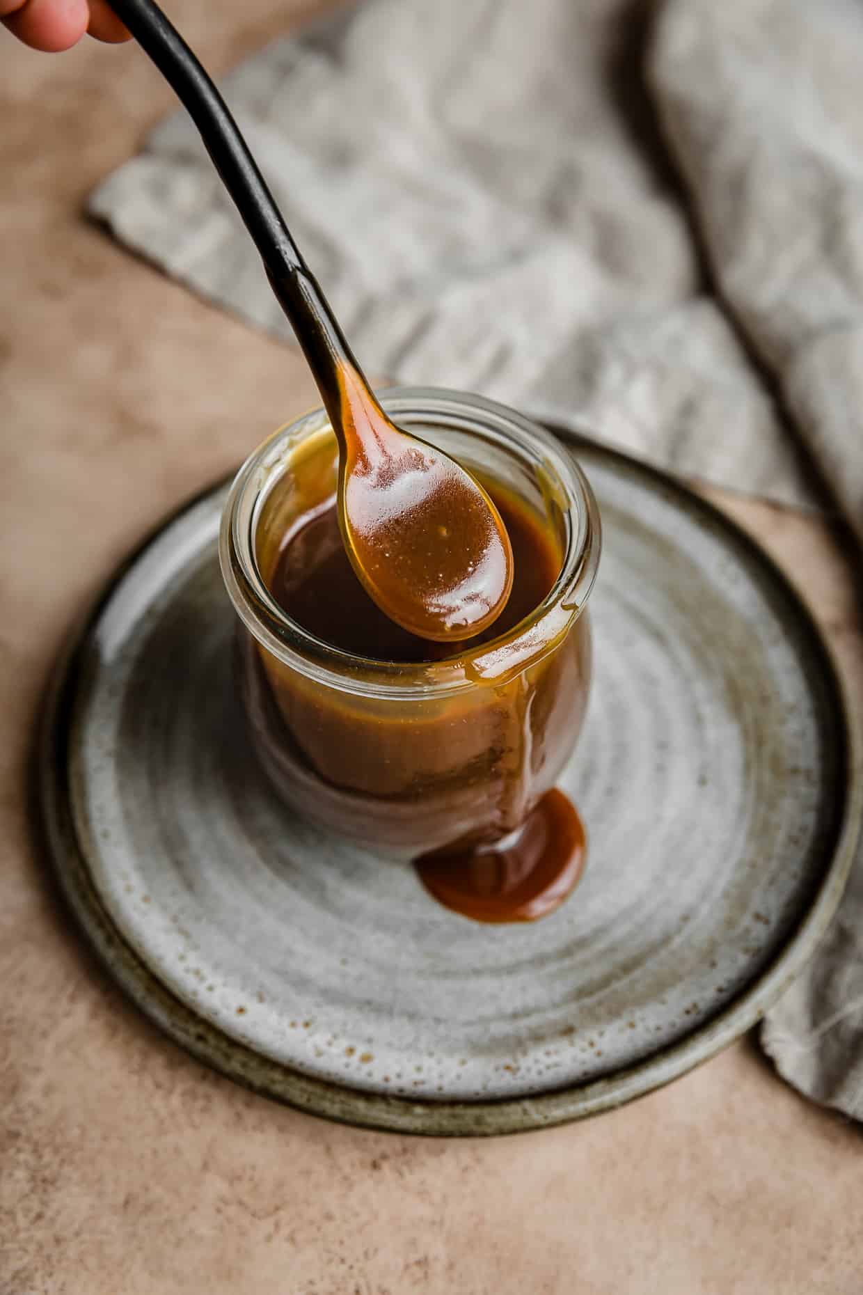 A spoon with Butterscotch Sauce on it.