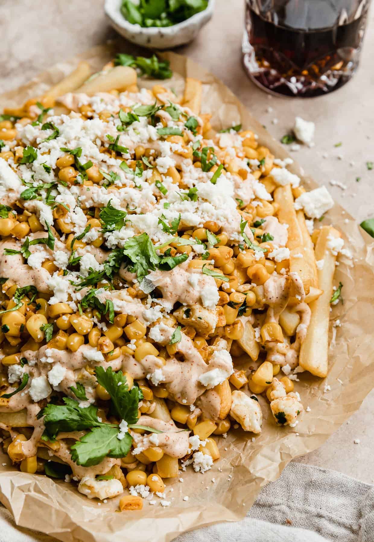 Mexican Street Corn fries on a parchment paper topped with queso fresco cheese and cilantro.