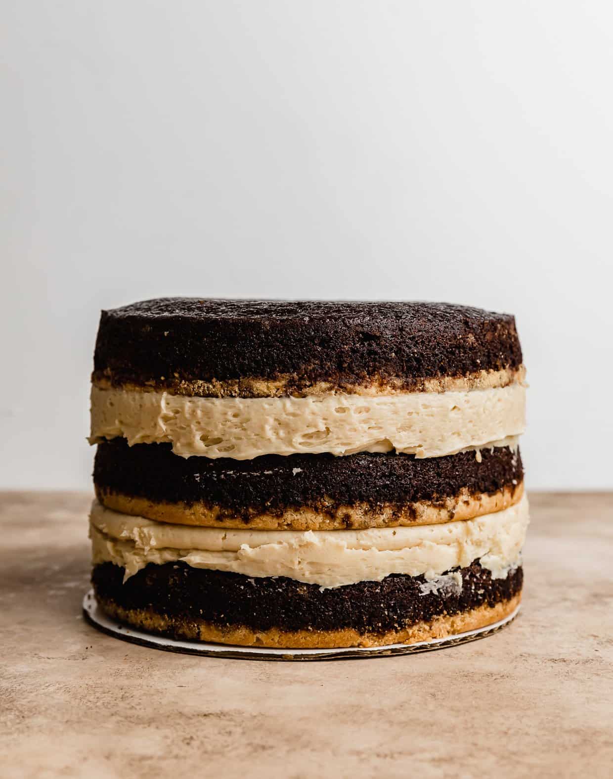 Three layer naked Twix Cake baked on shortbread crusts against a white background.