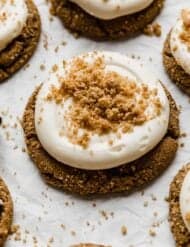 A graham cracker cookie topped with swirled cream cheese frosting and graham cracker crumbles.