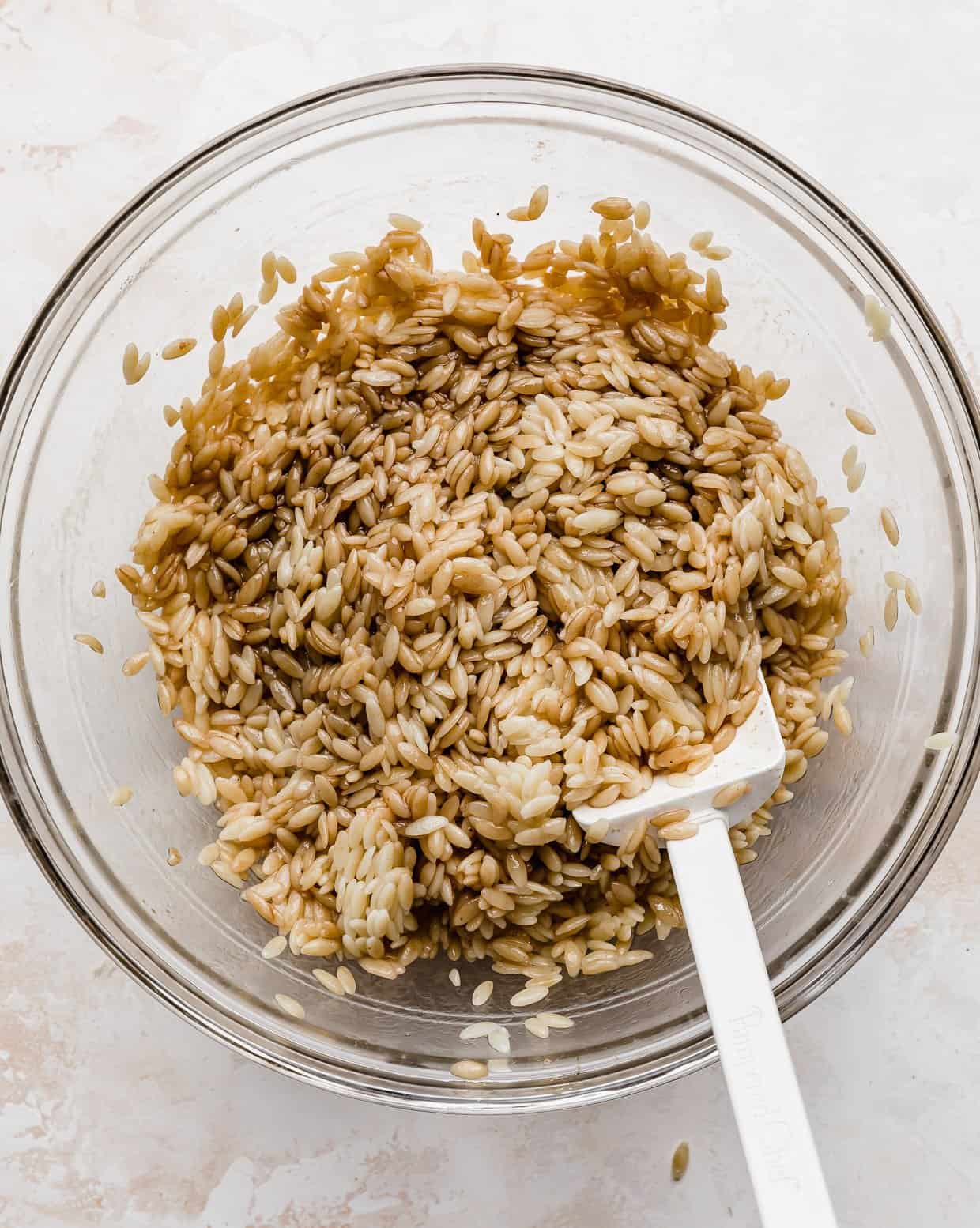 Orzo salad that has a balsamic dressing coating the noodles.