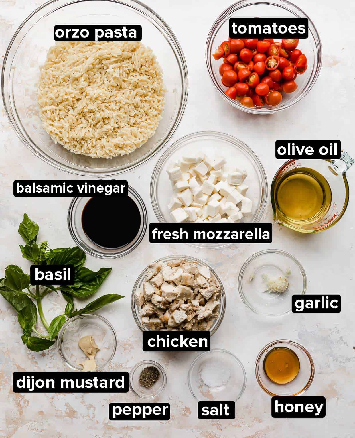 Orzo caprese salad ingredients on a white background.