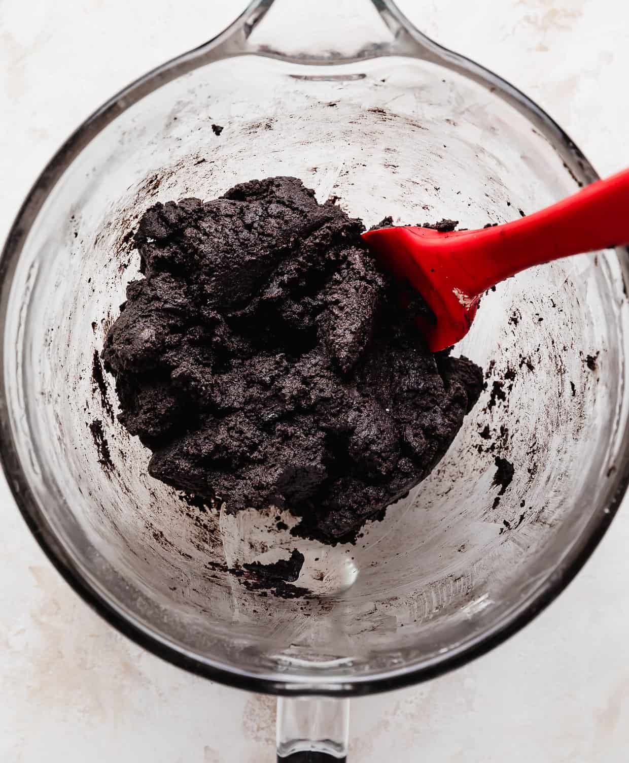 Oreo Birthday Cake Cookie dough in a glass mixing bowl on a white background.