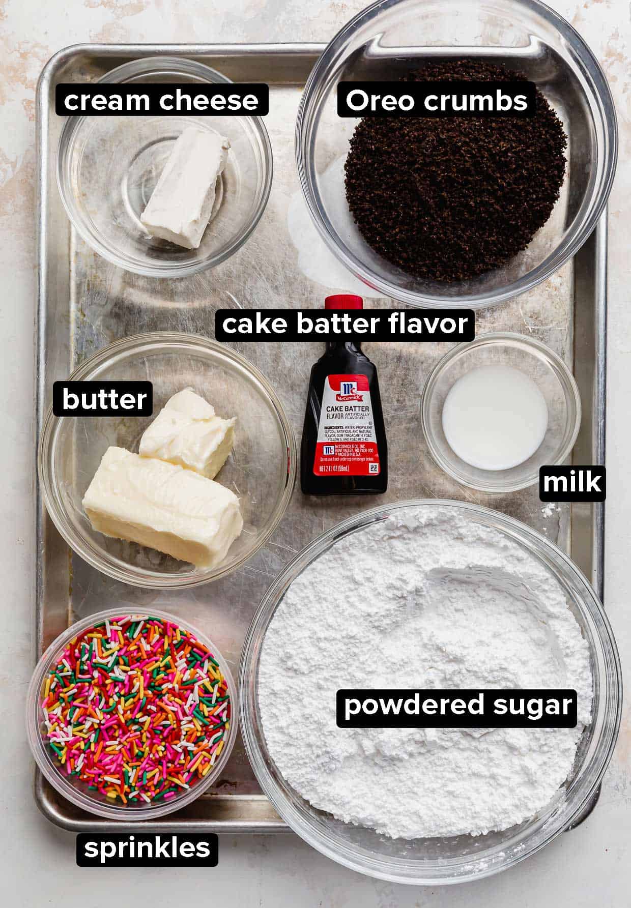 Ingredients used to top the Crumbl Oreo Birthday Cake Cookies: sprinkles, powdered sugar, butter, milk, cake batter extract, oreo crumbs, and cream cheese.