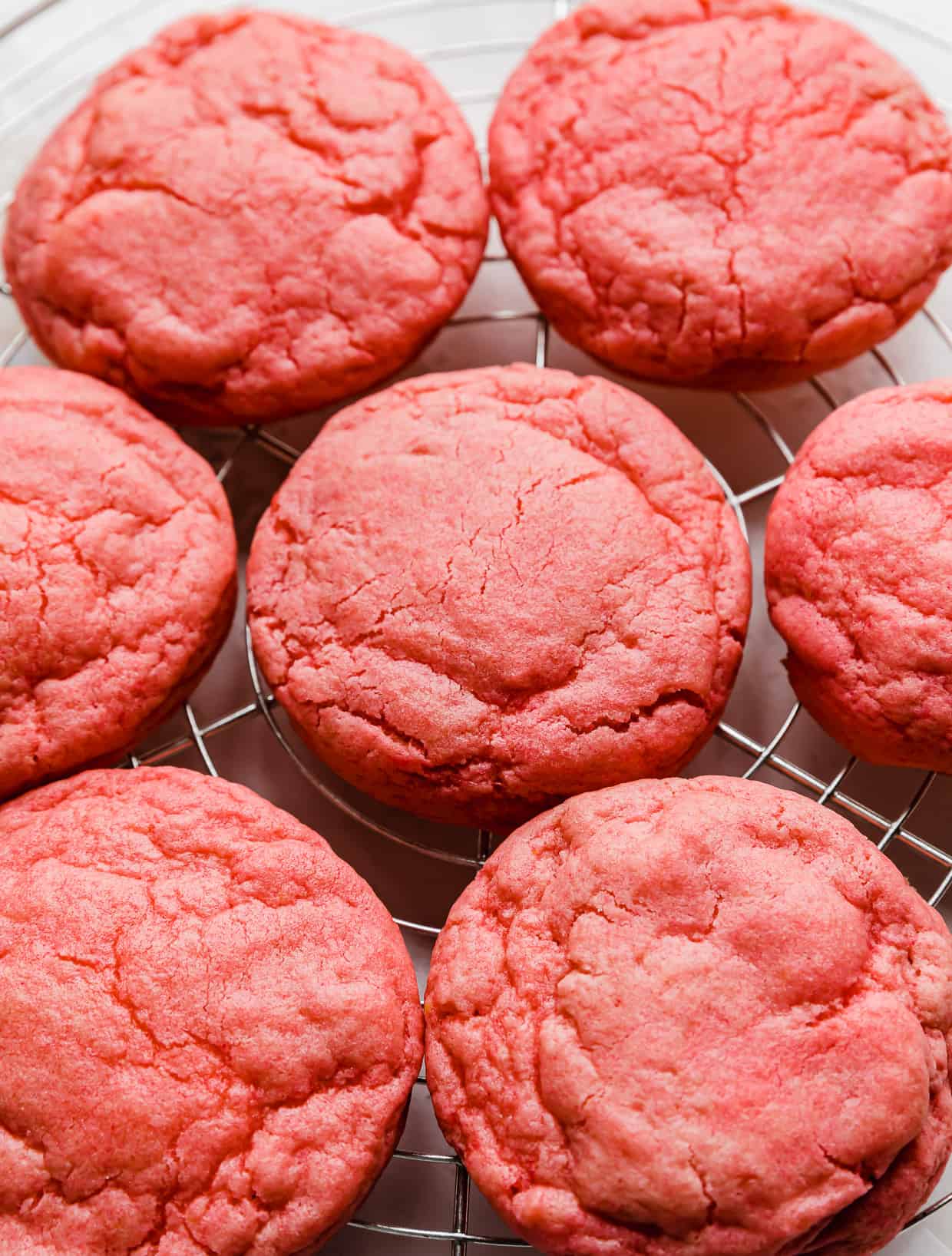 Crumbl Pink Velvet Cookies without frosting, on a wire cooling rack.
