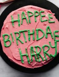 Hagrid cake that was made for Harry Potters Birthday, pink frosting and green lettering on a black plate.