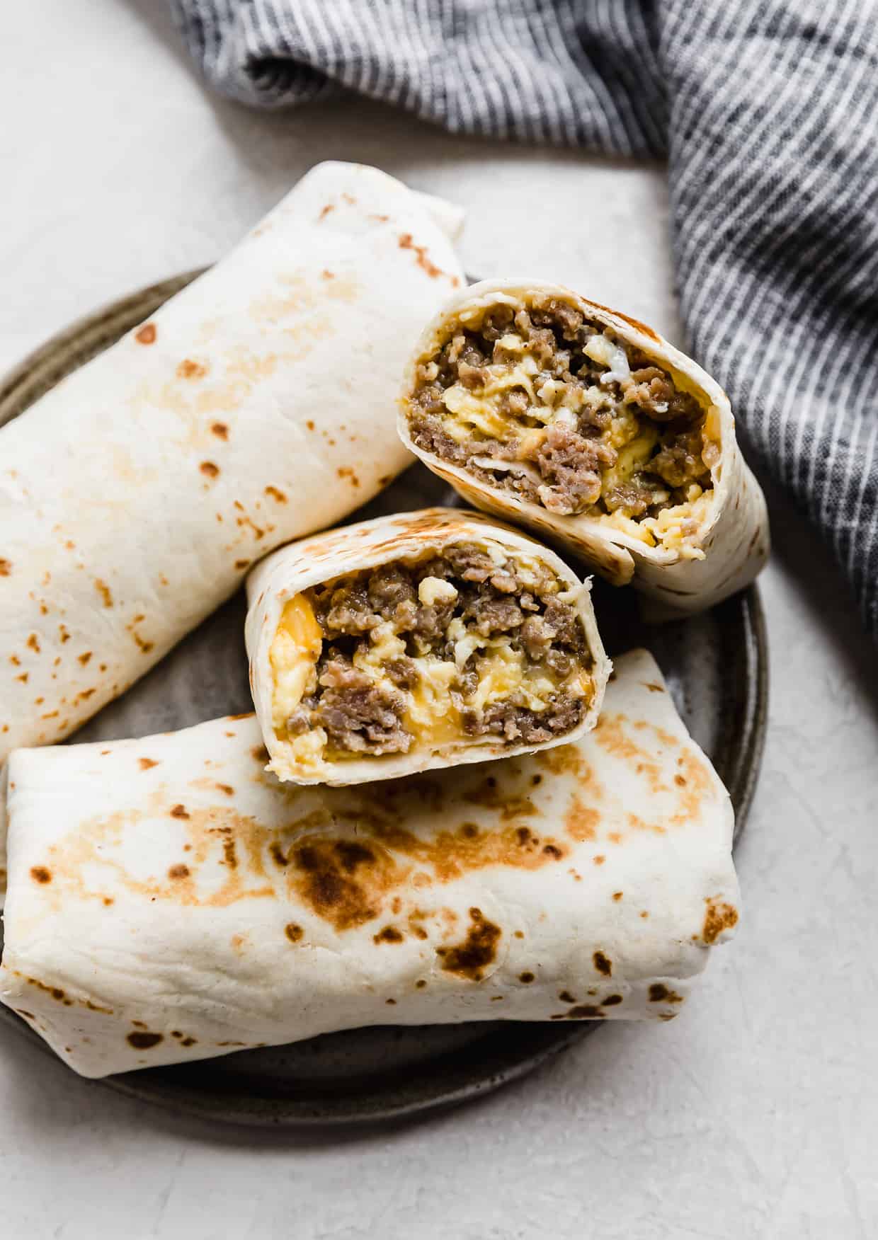 Jimmy Dean Breakfast Burrito cut in half, on a gray plate.