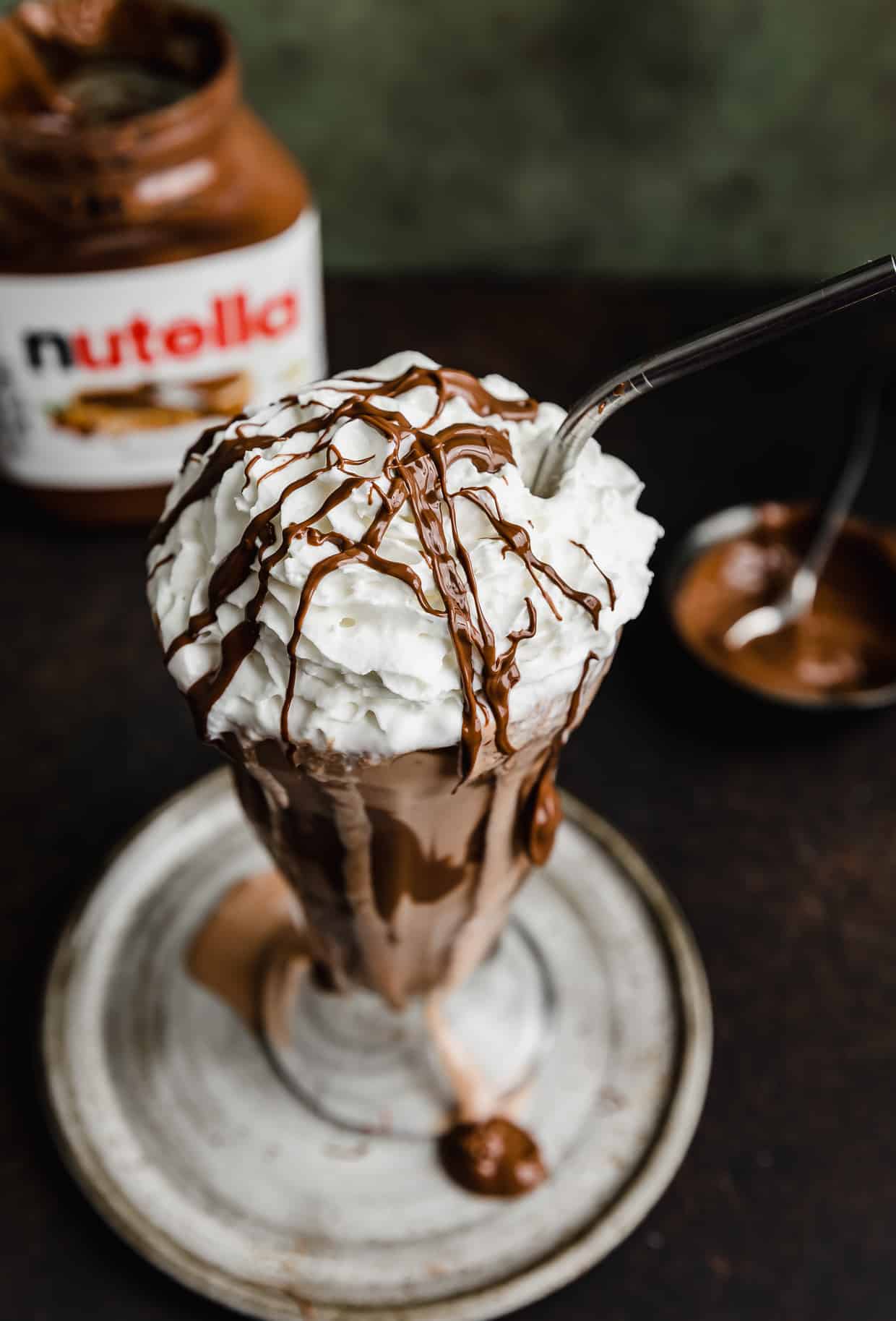 Overhead photo of whipped topping on a Nutella shake in a glass cup.
