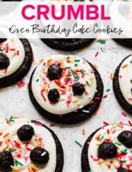 A dark cookie topped with white cake batter frosting, sprinkles, and oreo truffles with the words, "Crumbl Oreo Birthday Cake Cookies" written over the photo.