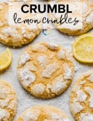 A Crumbl copycat Lemon Crinkle Cookie on a white background with lemon slices surrounding the cookie.