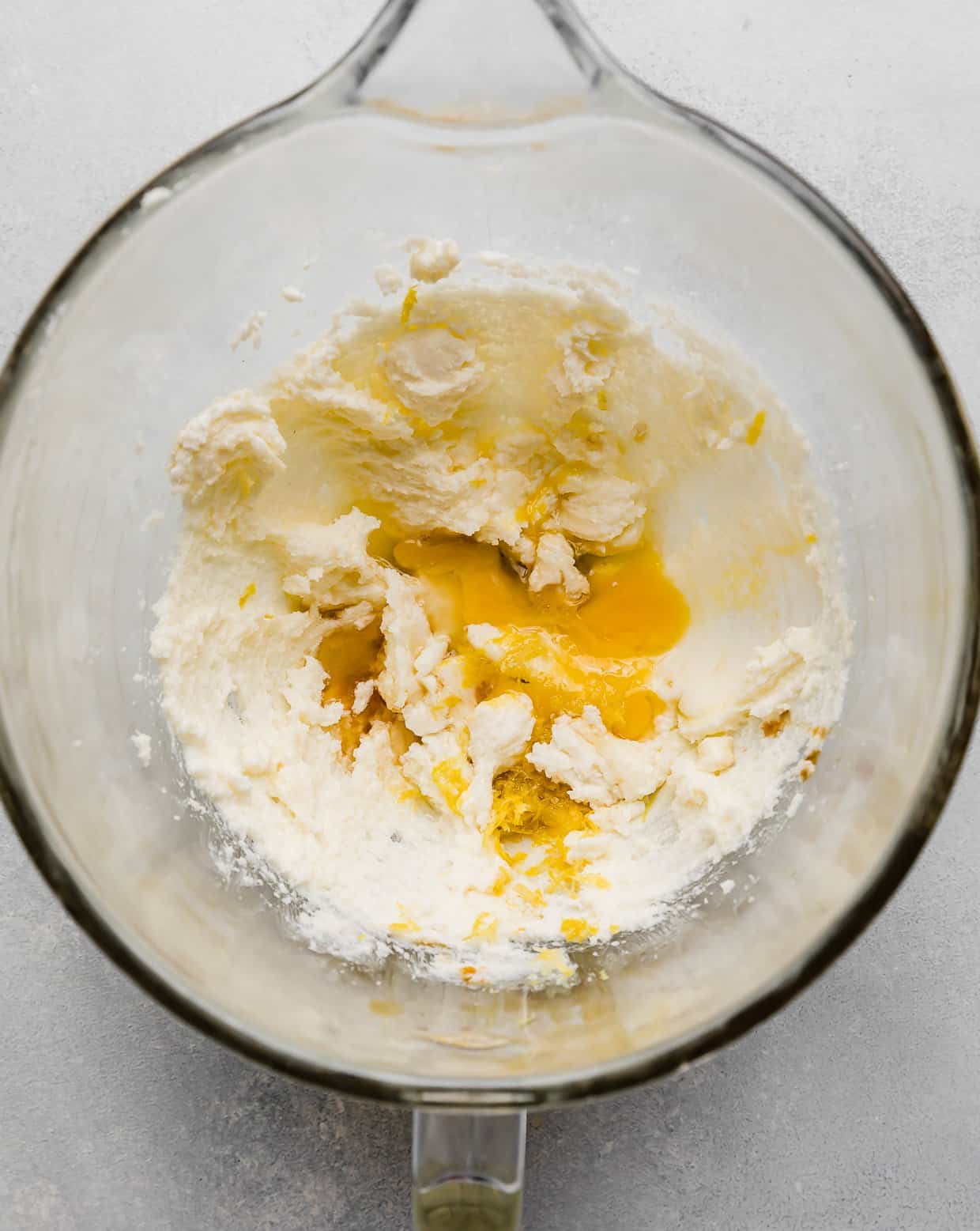 Creamed butter and sugar with egg and lemon zest in a glass bowl.