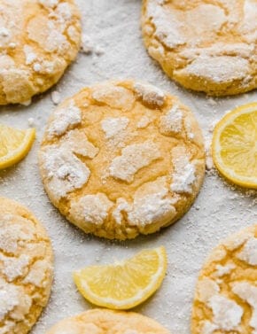 Crumbl Lemon Crinkle Cookies topped with powdered sugar on a white background.