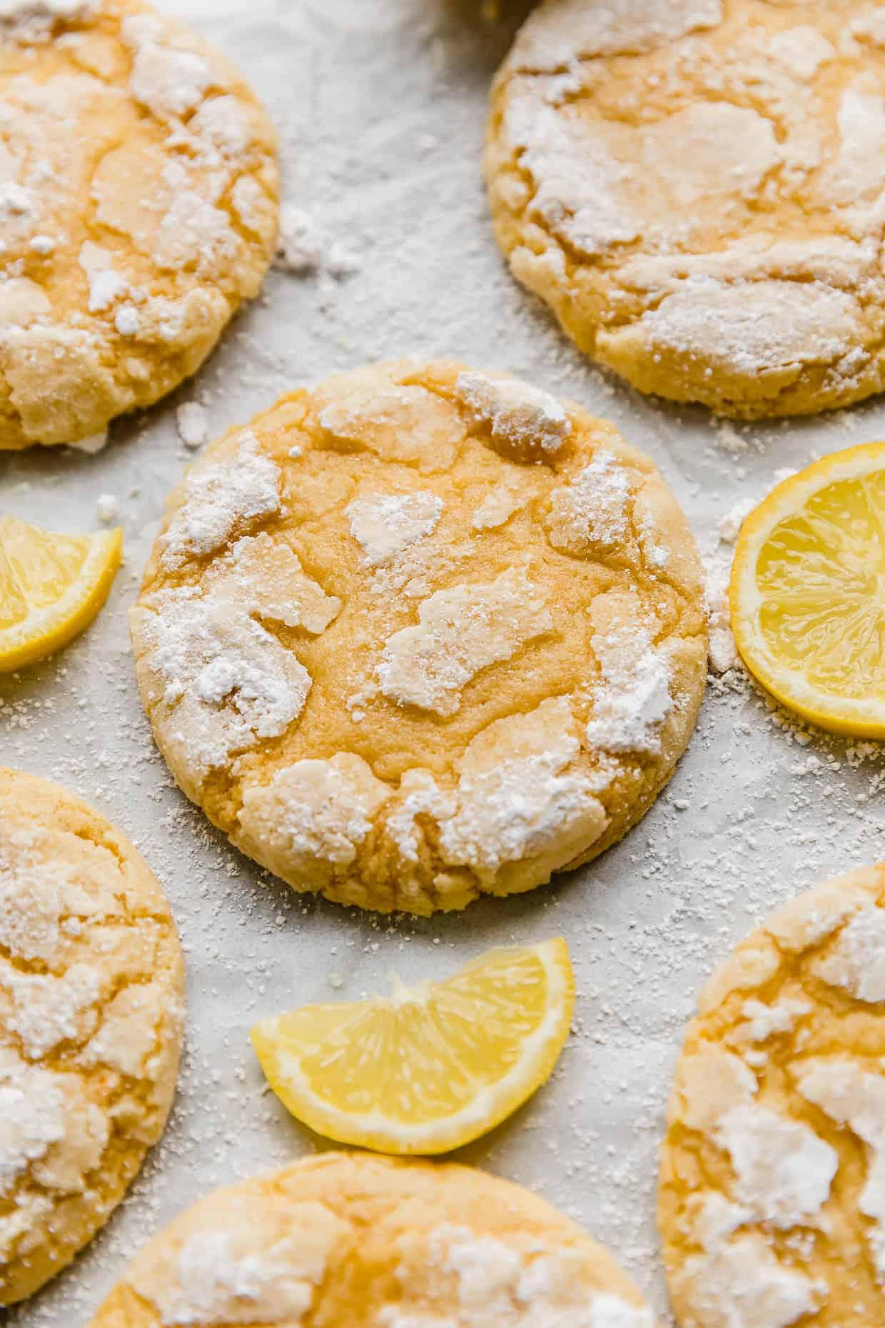 Crumbl Lemon Crinkle Cookies topped with powdered sugar on a white background.