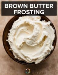 A bowl of brown butter frosting on a light brown textured background.