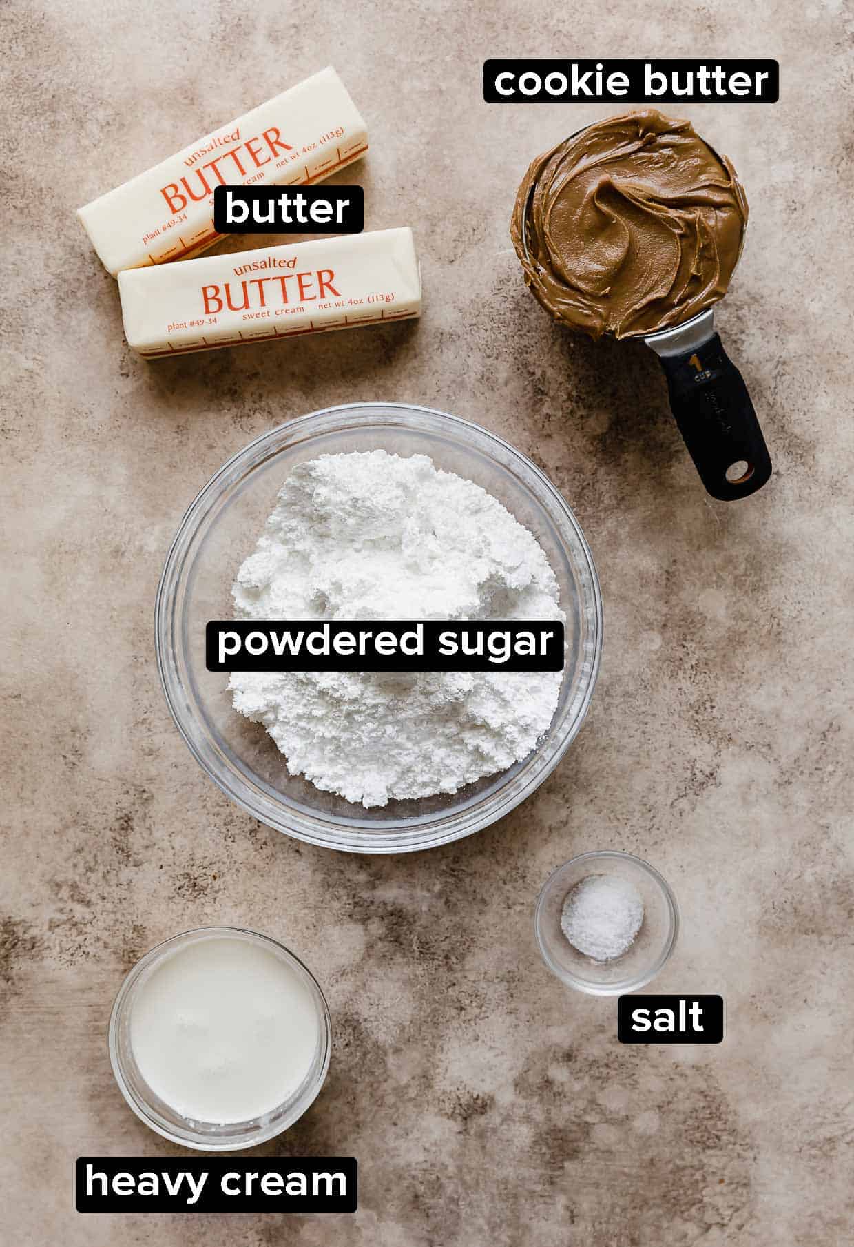 Ingredients used to make Biscoff Buttercream on a tan textured background.
