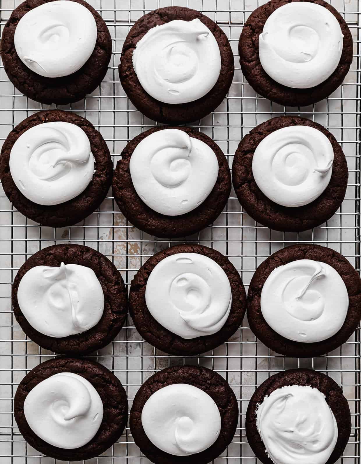 Marshmallow frosting topped chocolate cookies.