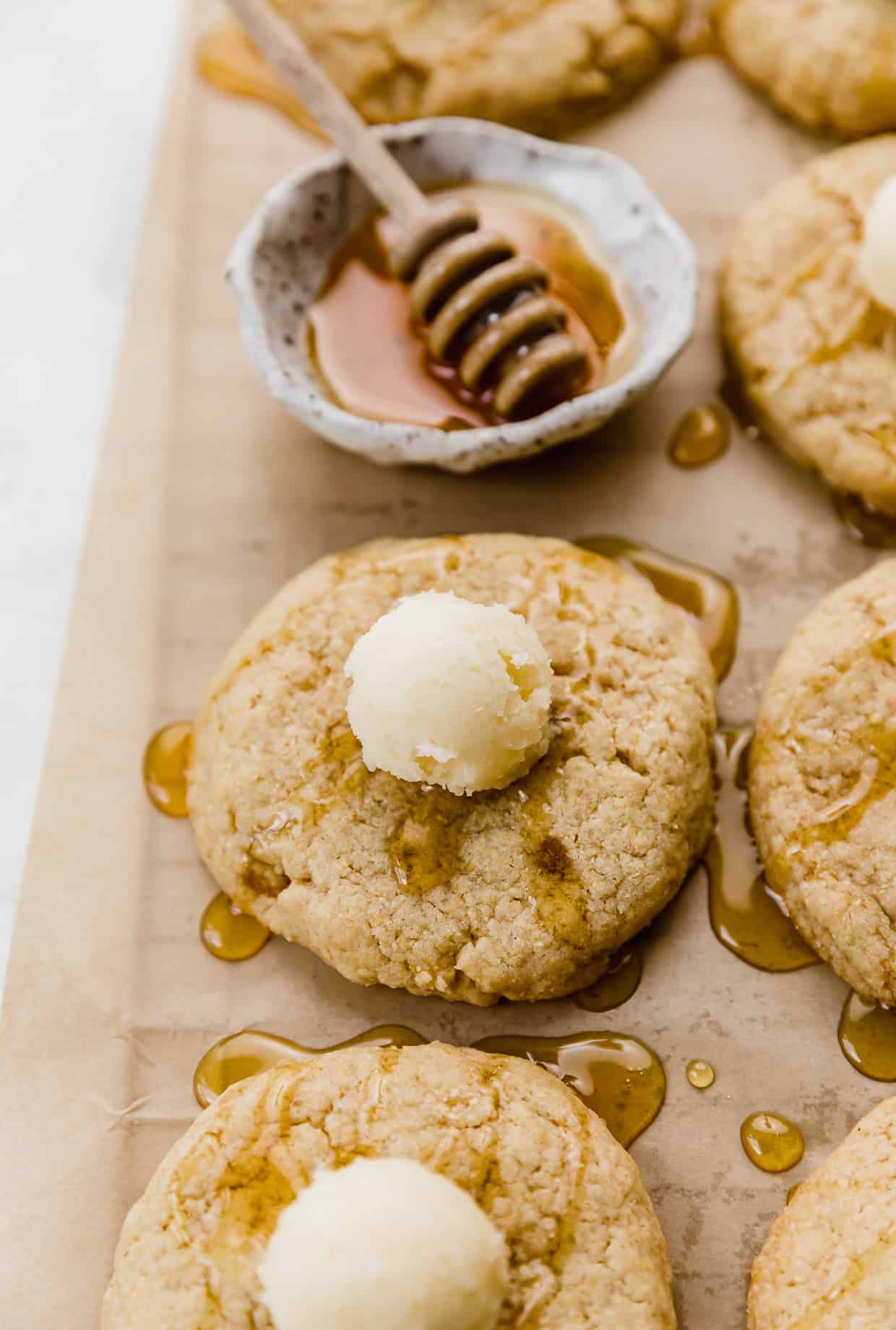 A copycat Crumbl Cornbread Cookie topped with honey and a ball of butter.