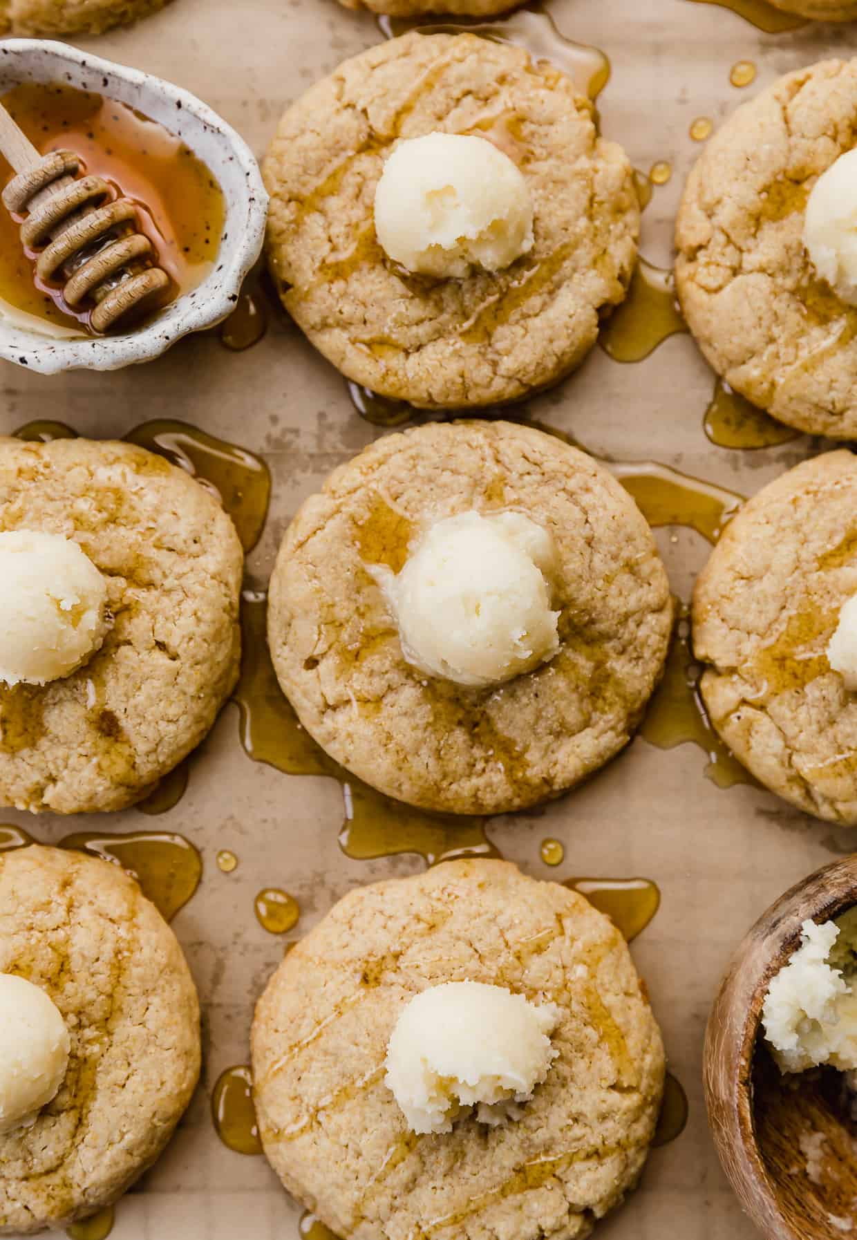 Cornbread cookies topped with honey and a small butter ball on top of each cookie.