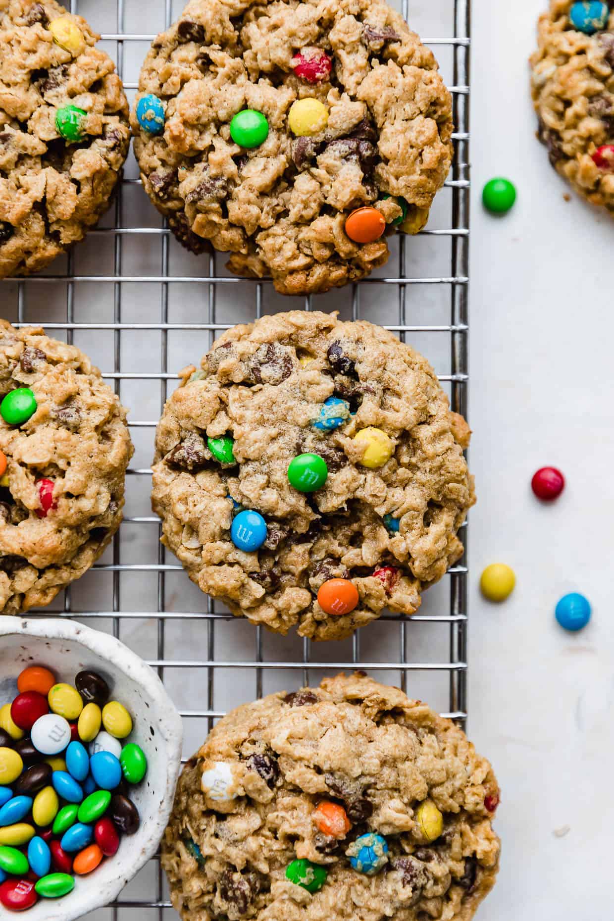 Soft & Chewy Monster Cookies filled with mini M&M's, on a wire cooling rack.