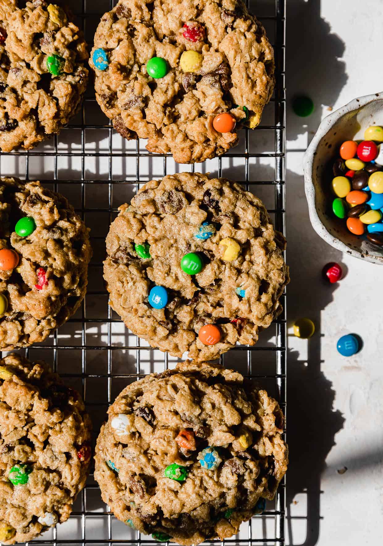 Soft & Chewy Monster Cookies on a wire cooling rack that's on a white background.