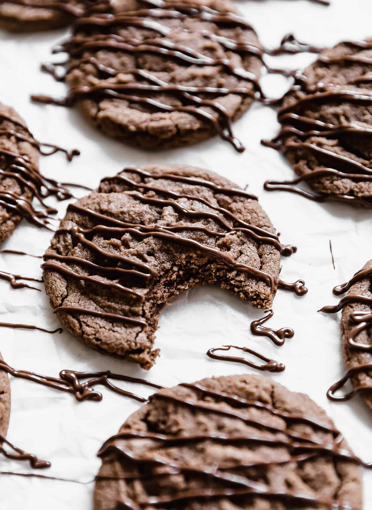 Nutella Cookies drizzled with Nutella and a bite taken out of it.