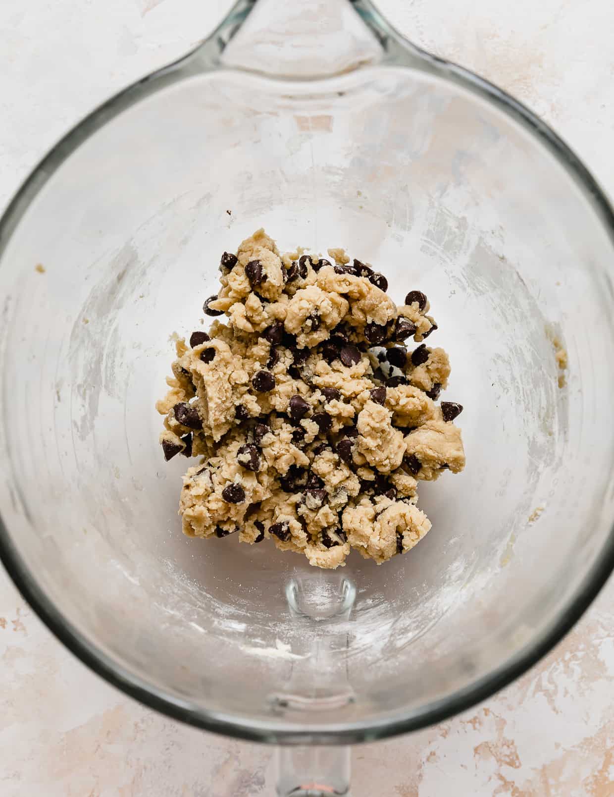 A glass bowl with Small Batch Chocolate Chip Cookie dough in it.