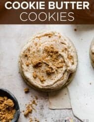 A Cookie Butter Cookie topped with frosting and crushed Biscoff cookie crumbs with the words, "Cookie Butter Cookies" in white text over the photo.
