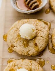 A butter ball on top of a honey drizzled Crumbl Cornbread Cookie.
