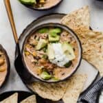 Sour cream and avocado on top of a bowl filled with cream cheese chicken chili recipe.