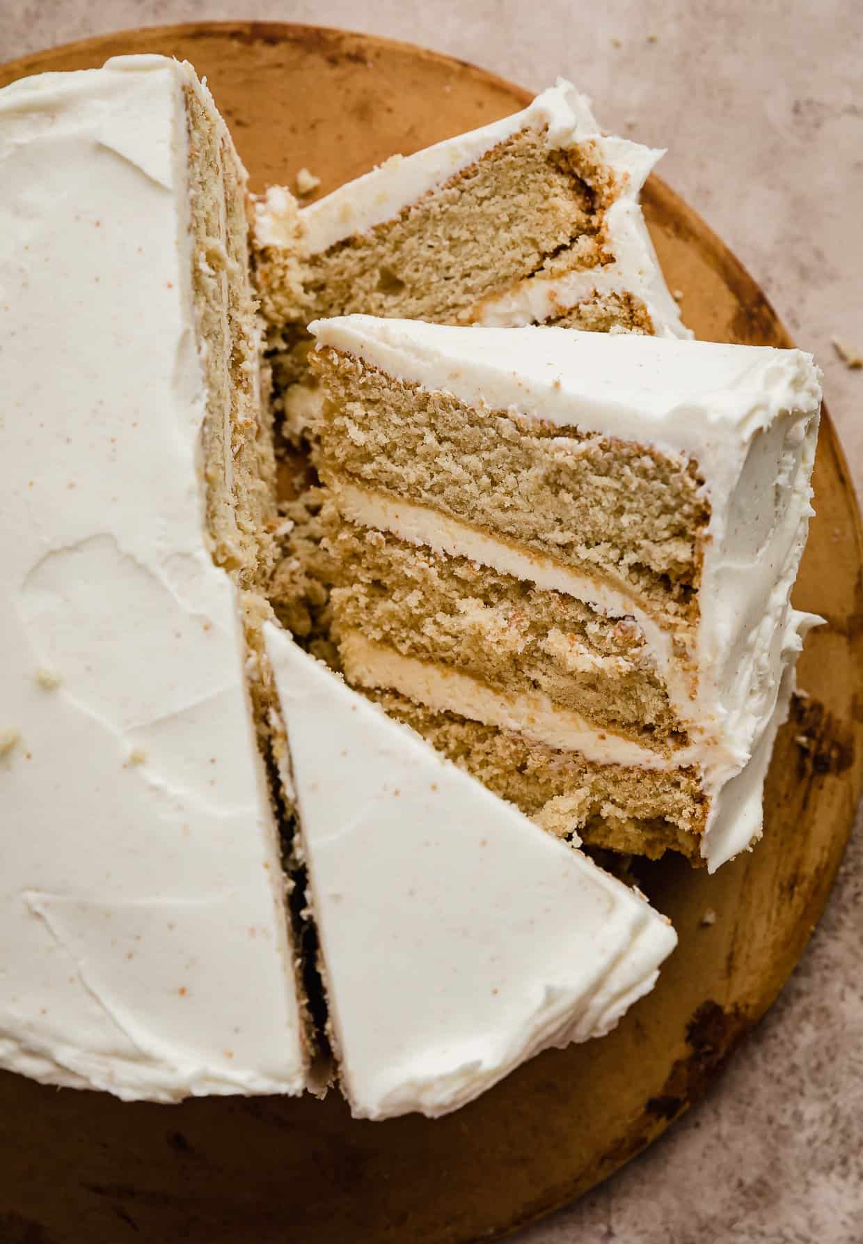 Slices of Brown Butter Cake topped with brown butter frosting on a brown background.