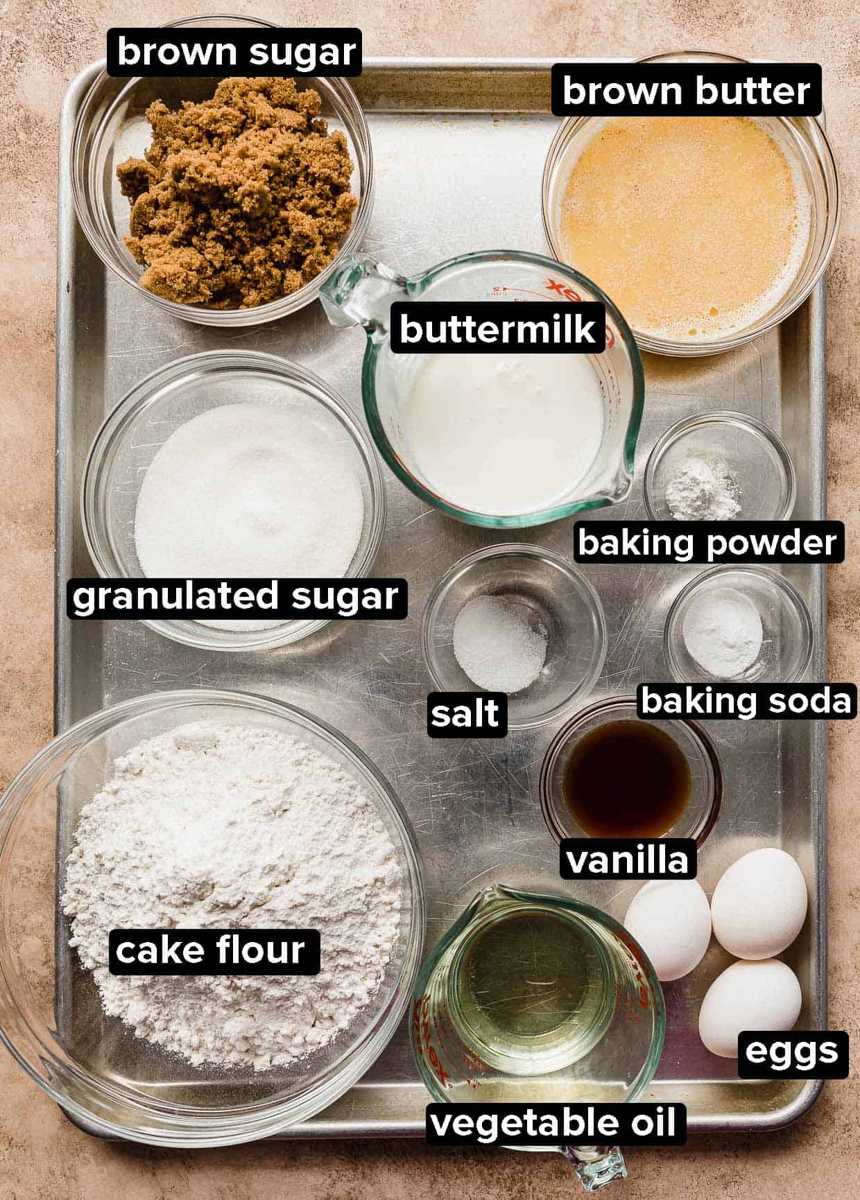 Brown Butter Cake ingredients portioned into glass bowls on a silver baking sheet.